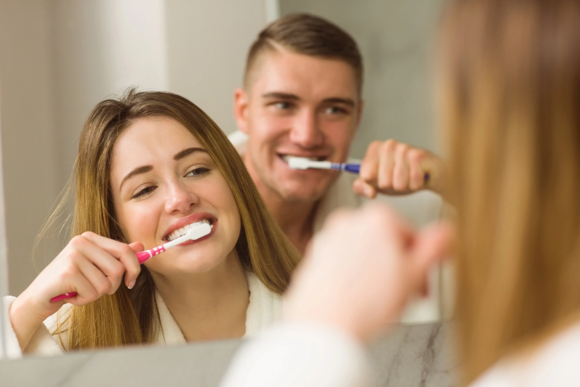 happy-couple-brushing-teeth-after-going-to-the-dentist-in-Cary-NC